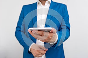 Businessman holds lap top in his hand. Business concept with man holding mobile phone with touch screen. Businessman in