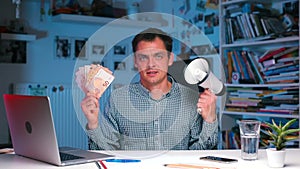 Businessman holds money and a megaphone in his hands