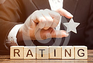 Businessman holds one star above the wooden blocks with the word Rating. Concept of negative feedback. Low quality and service