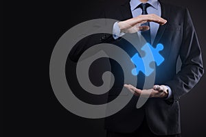 Businessman holds a piece of puzzle jigsaw in his hands.The concept of cooperation, teamwork, help and support in business