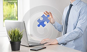 Businessman holds a piece of puzzle jigsaw in his hands.The concept of cooperation, teamwork, help and support in business