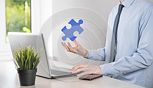 Businessman holds a piece of puzzle jigsaw in his hands.The concept of cooperation, teamwork, help and support in business