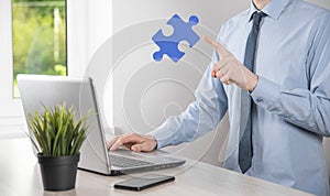 Businessman holds a piece of puzzle jigsaw in his hands.The concept of cooperation, teamwork, help and support in business