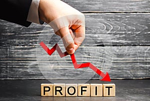 A businessman holds a red arrow to down and the inscription `profit`. Unsuccessful business and poverty. Profit decline. Loss of i photo