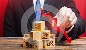 Businessman holds a red down arrow over the boxes. Business industrial production drop rate. Shortage of products. Low supply