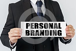 A businessman holds a sign in his hands which says - PERSONAL BRANDING