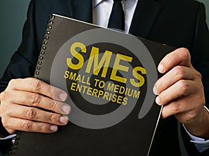 Businessman holds SMEs Small to Medium Enterprises