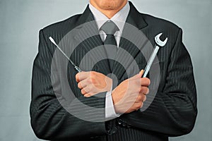 Businessman holds tools, concept of business creation