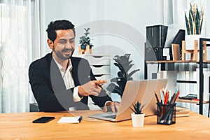 Businessman holds virtual office meeting from desk. Fervent