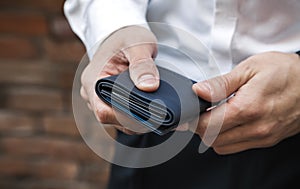 A businessman holds a wallet in his hands