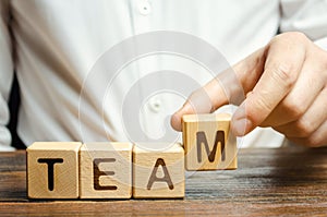 Businessman holds wooden blocks with the word Team. Team management concept. Teamwork. Hiring. Recruitment staff. Work in