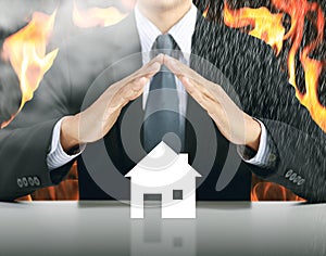 Businessman and home with fire background