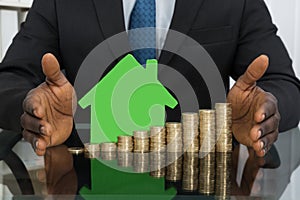 Businessman With House Model And Coins