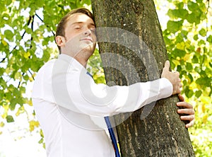 Businessman hugging tree img