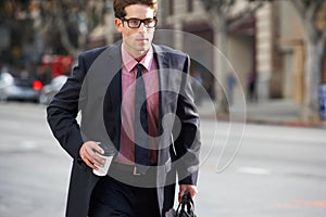 Businessman Hurrying Along Street Holding Takeaway Coffee photo