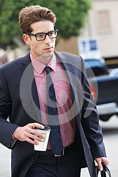 Businessman Hurrying Along Street Holding Takeaway Coffee photo