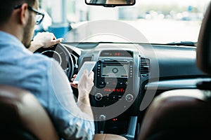 Businessman ignoring safety and texting on mobile phone while driving