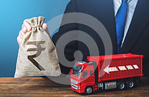 Businessman with indian rupee money bag and truck. Good salaries for drivers. Rising prices, global containers shortage crisis.