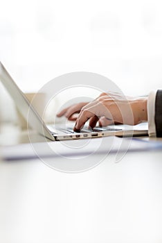 Businessman inputting data on his laptop computer