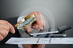 Businessman Inspecting Document With Magnifying Glass