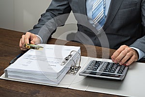 Businessman inspecting receipts in office photo