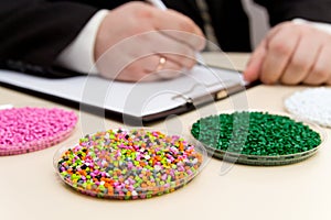 Businessman inspects plastic pellets for industry. Plastic raw materials in granules . Polymer, plastic resin