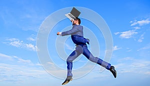 Businessman inspired entrepreneur feels powerful going to change world. Man inspired holds laptop above while jump