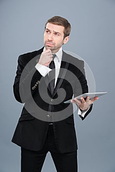 Businessman is intrigued by the news he is reading on his tablet pc