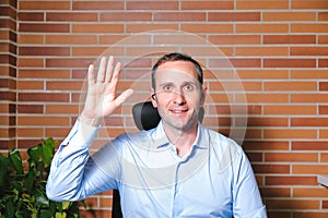 Businessman introducing himself and waving at the camera. Video call concept