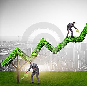 Businessman in investment concept watering financial line chart