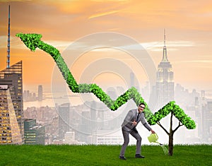 Businessman in investment concept watering financial line chart