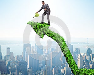 Businessman in investment concept watering financial line chart