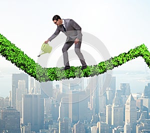 Businessman in investment concept watering financial line chart