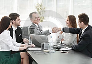 Businessman and investor shake hands at the negotiating table