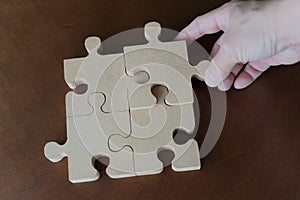 Businessman with jigsaw puzzle pieces in office. concept of business hand holding puzzle pieces on puzzle background