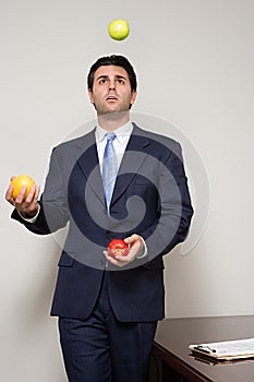 Businessman juggling fruit