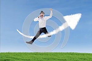 Businessman jump and calling over success sign outdoor