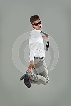 Businessman, jump and celebration for win in studio, professional and energy for success or victory. Male person