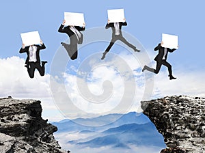 Businessman jumping with billboard on the mountain