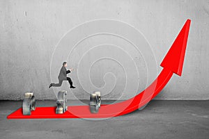 Businessman jumping over money symbols on growing red arrow