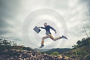 Businessman jumping over the mountain, business worker concept