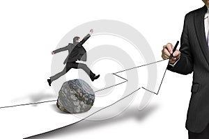 Businessman jumping over rock in drawing road with growing arrow