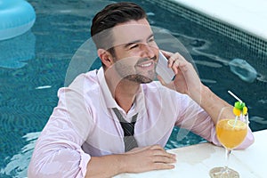 Businessman jumping into pool with cellphone