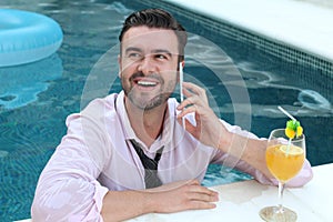Businessman jumping into pool with cellphone