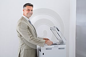 Businessman Keeping Paper On Photocopy Machine In Office