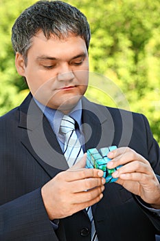 Businessman keeps in hand cube outdoor in summer photo