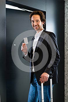 Businessman with key card for room door in hotel