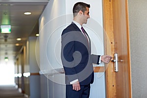 Businessman with keycard at hotel or office door