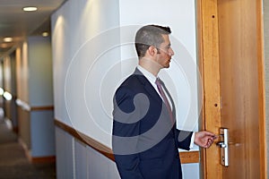 Businessman with keycard at hotel or office door photo