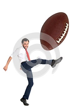 Businessman kicking an American football ball